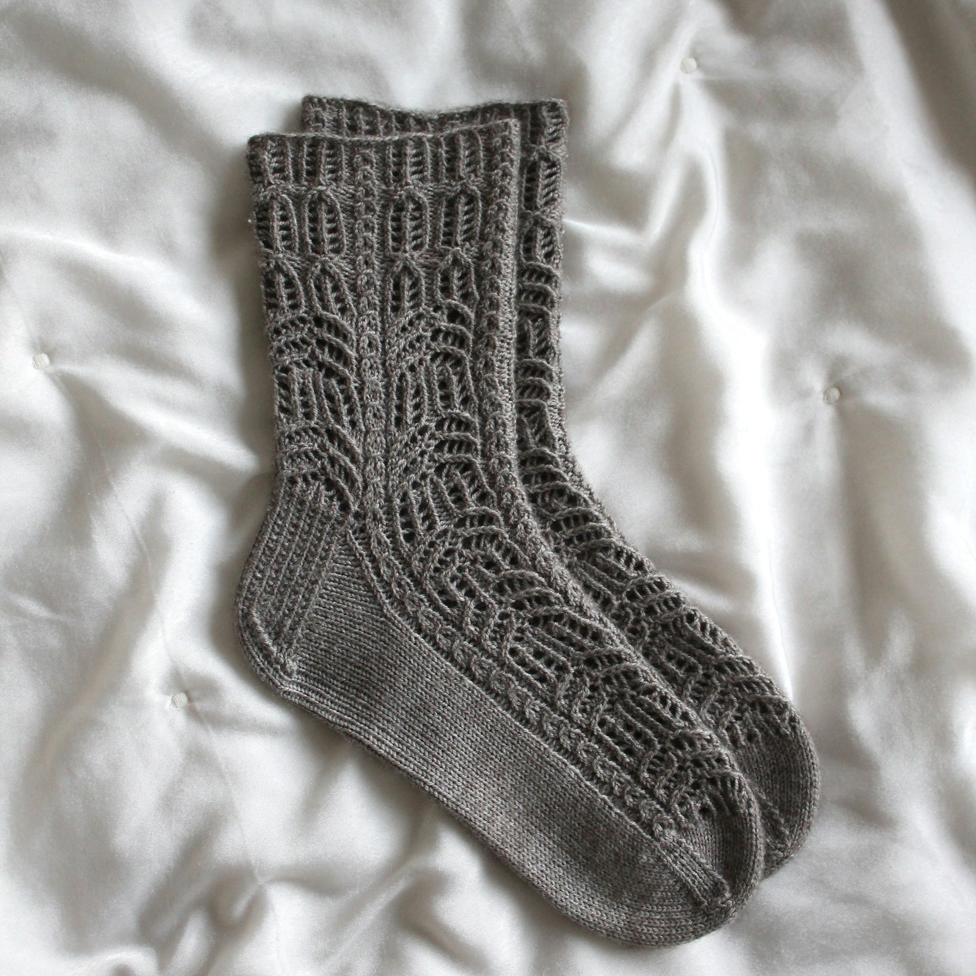 Soft grey wool sock laid on white fabric