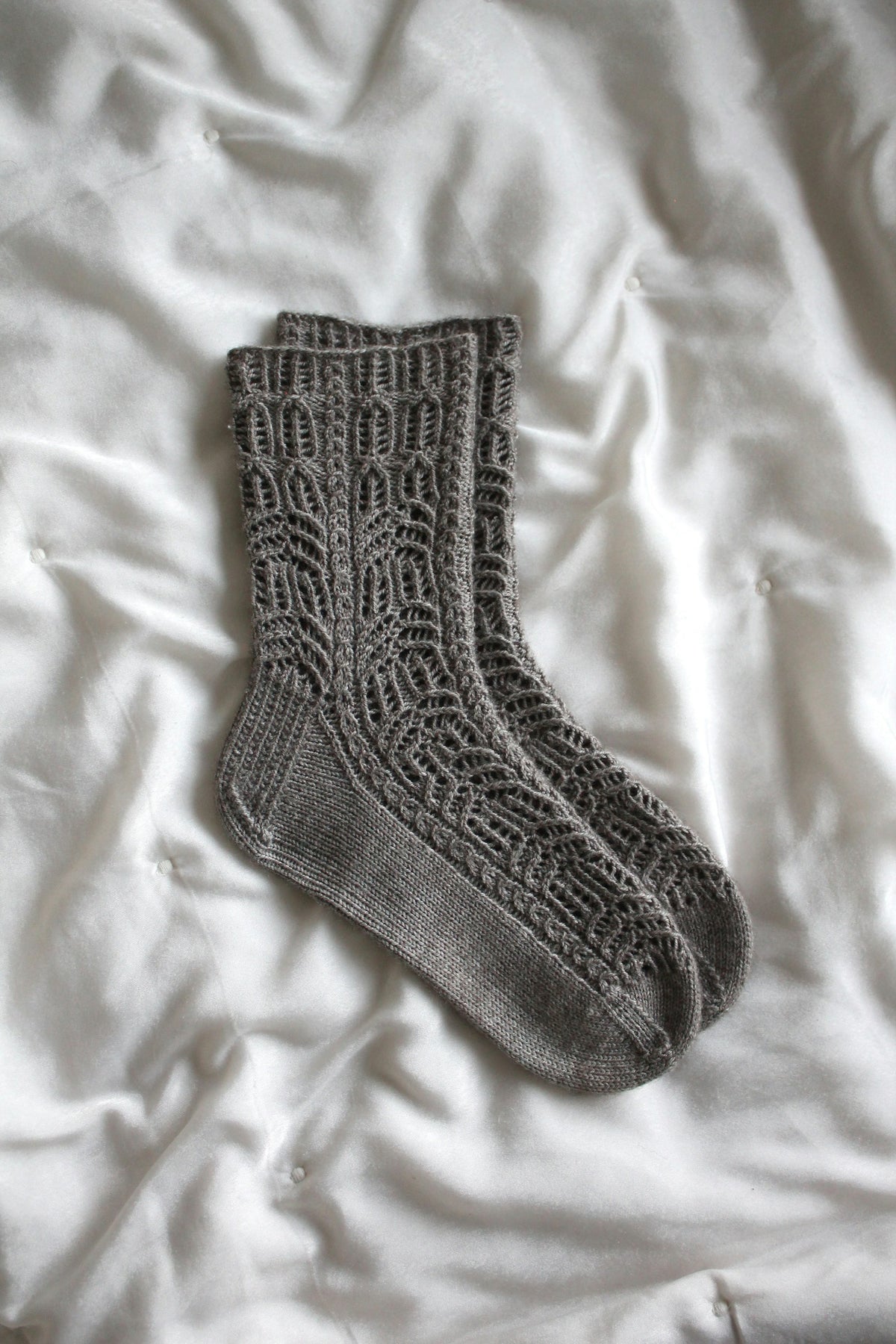 Soft grey wool sock laid on white fabric