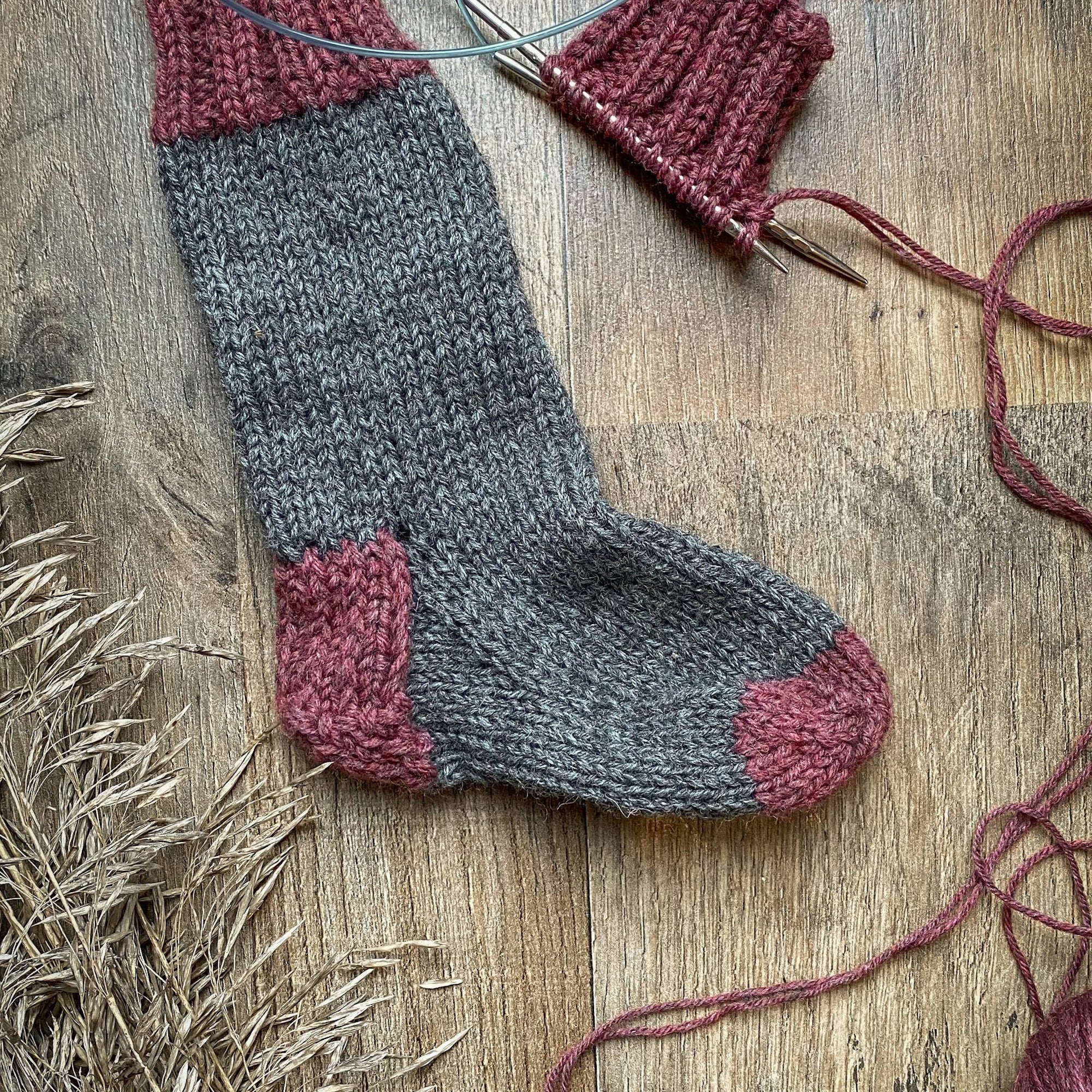 A pair of knitted wool socks on a wooden floor