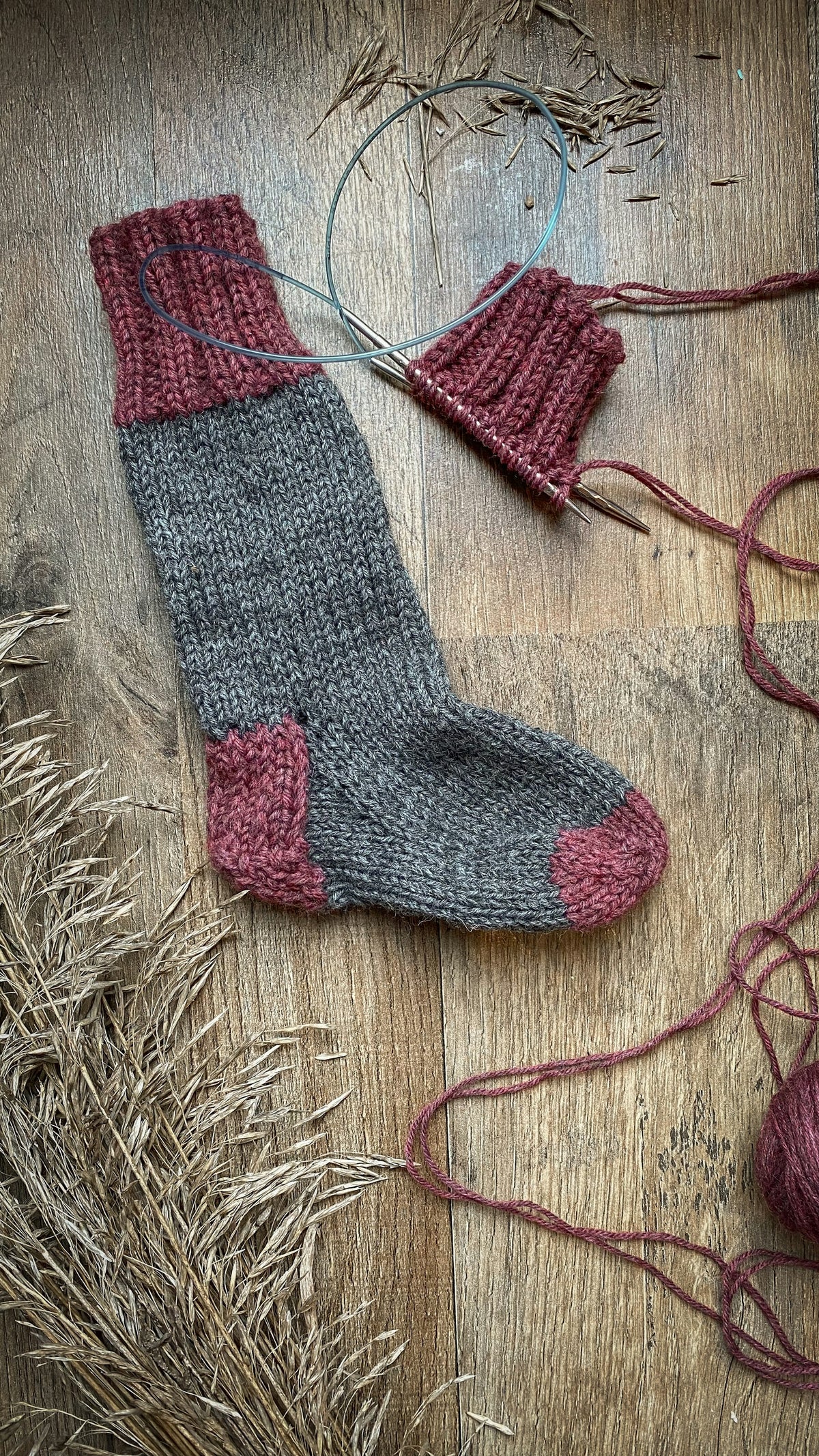 A pair of knitted wool socks on a wooden floor