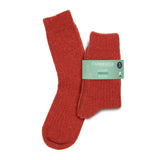 A pair of red flecked ribbed merino wool boot socks in a printed merino paper band on a white background.