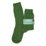 A pair of green flecked ribbed merino wool boot socks in a printed merino paper band on a white background.