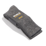 A pair of dark gray knit boot socks folded and wrapped in a black paper band with white and yellow text reading 'NOBLE ALPOE SOCKS' and 'BOOT'.