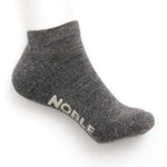 A grey marl alpaca no-show sock with the Noble logo knitted into the sole, shown on a white background.