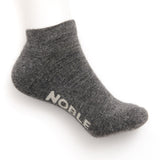 A grey marl alpaca no-show sock with the Noble logo knitted into the sole, shown on a white background.